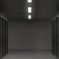 信息安全工程师站在服务器机房走廊，身着深色工装，画面科技感强